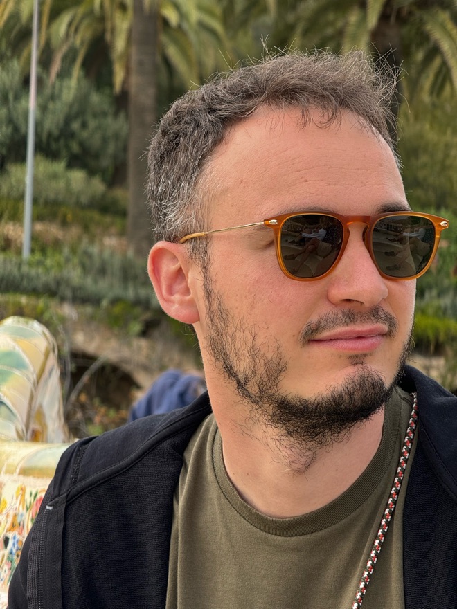 Luca with orange sunglasses, in a park with palm trees